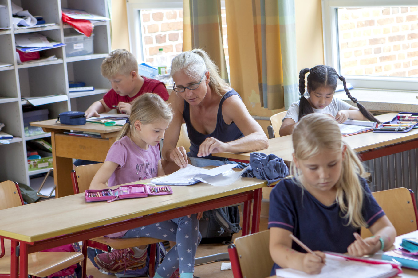 Frau betreut Kinder in der Schule